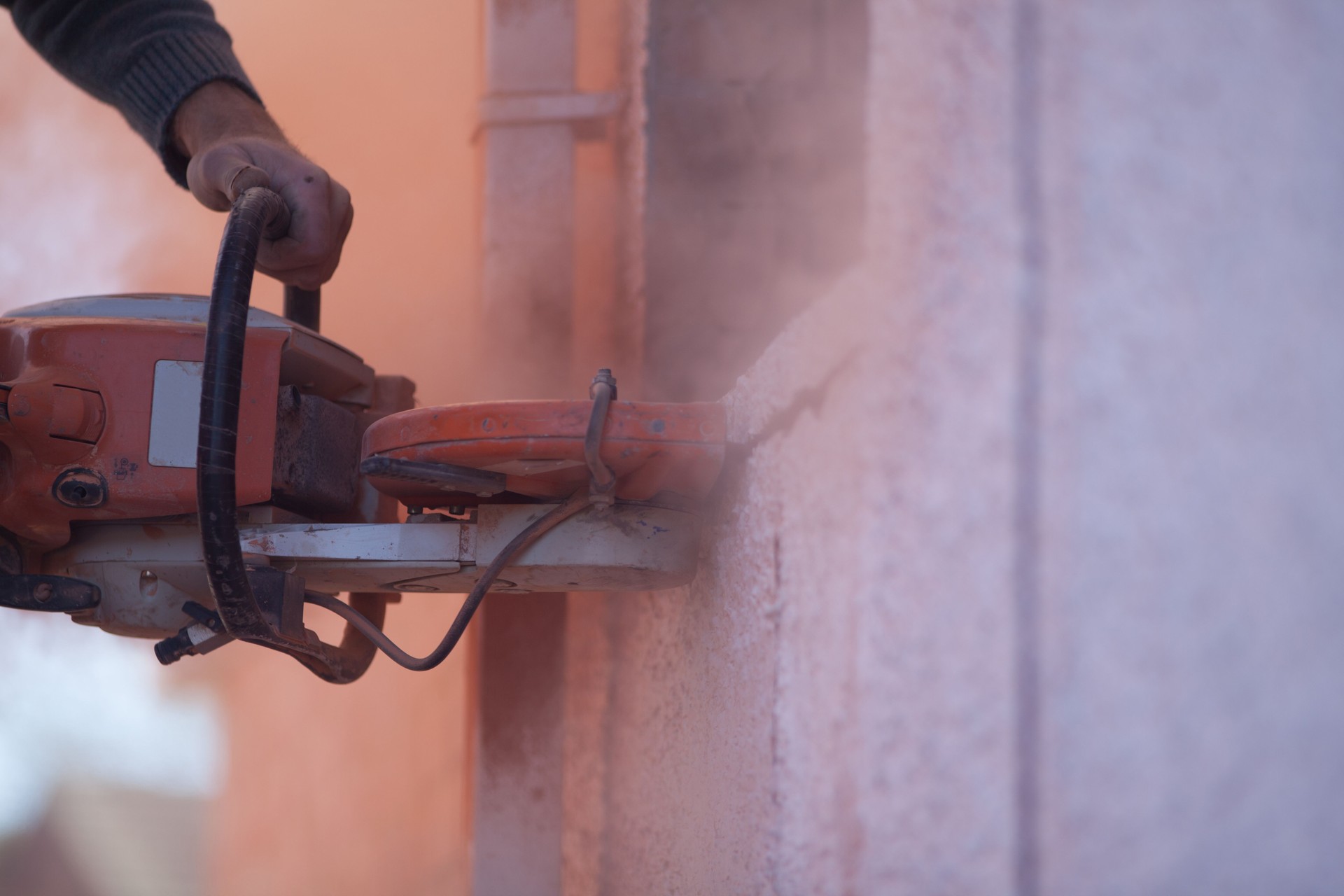 Builder Using A Cut Off Saw On A Brick Wall